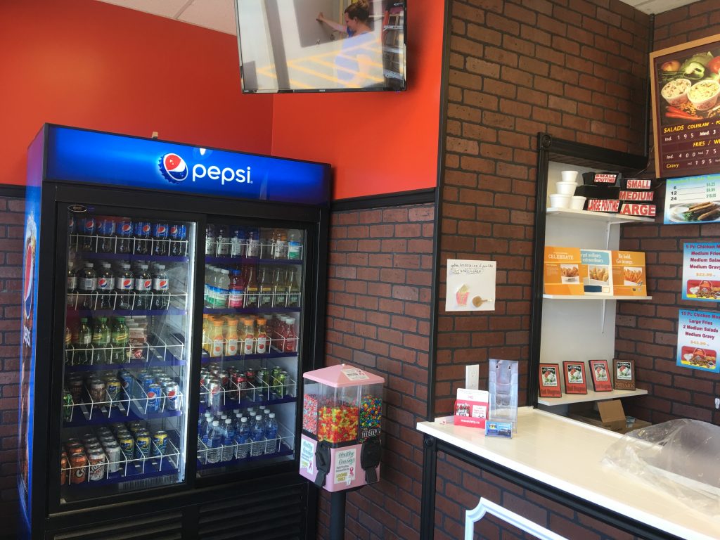Interior of fast food restaurant with Pepsi fridge.